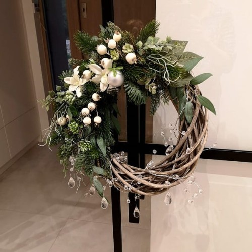 Asymetryczny wianek na drzwi ze świerku na wiklinowym kole.